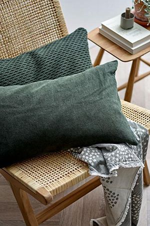Kissen aus dicht gewebter Baumwolle in Petroltönen auf Holzstuhl